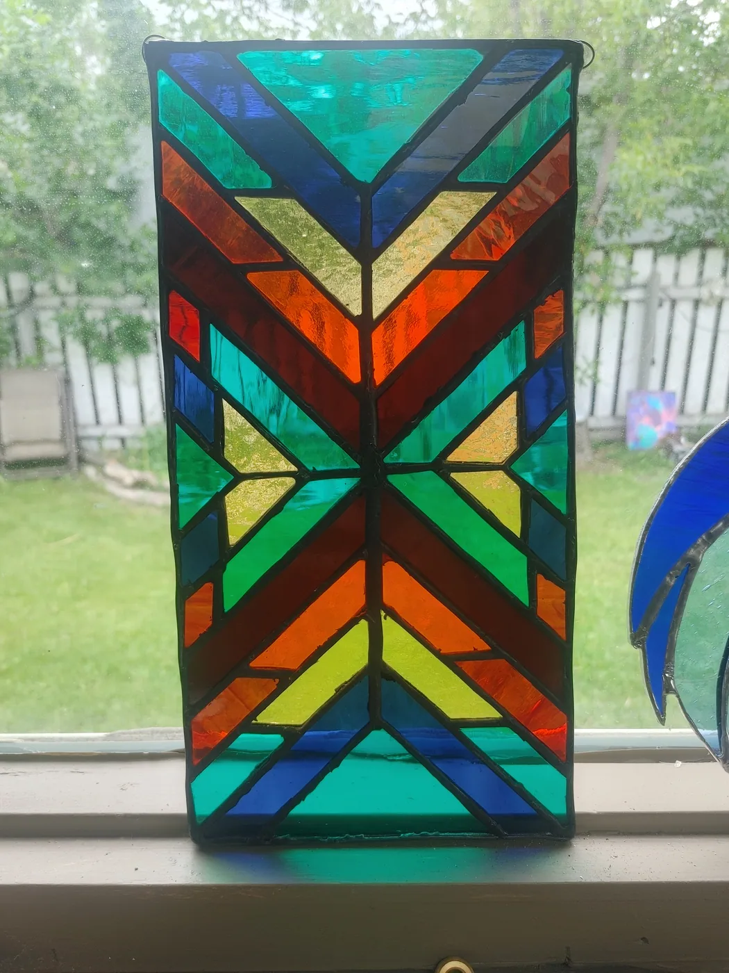 Rectangular geometric stained-glass panel in bright layered colours